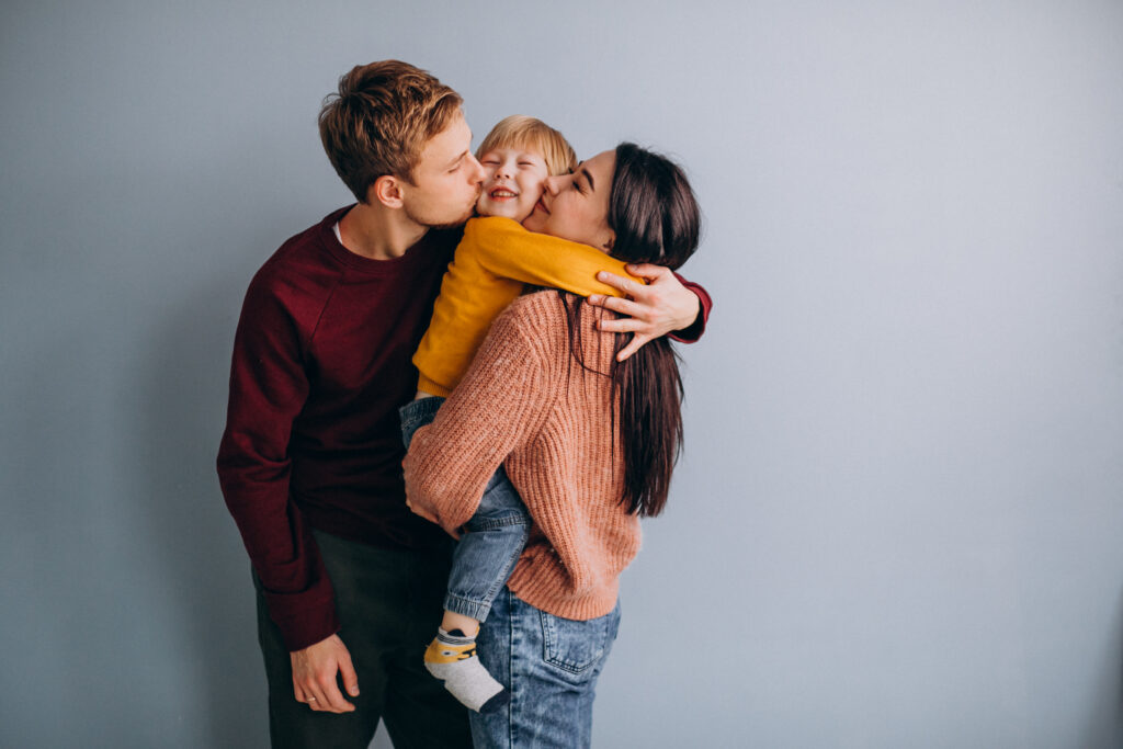 Young family with little son embracing together 